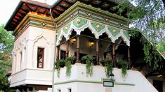 a white building with green plants on the balconies