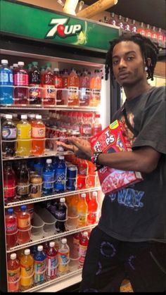 a man standing in front of a vending machine filled with drinks and juices