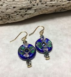 "Sooo Pretty These Healing Earrings. Made With, 3mm Faceted Sapphire Blue Glass Crystals, 4mm Green Vitrail Bicone Swarovski Crystals, 1/2 Inch Round Blue Cloisonné Beads, Gold Plated Tiny Flat Spacers, 14Kt Gold Plated Chandelier Ear Wires And Flat Head Pins. (Materials Are Lead And Nickel Free) CRYSTAL also known as Clear Quartz, is the \"Stone that brings the Energy of the Stars to the Soul.\" It aligns human energies - thoughts, emotions and consciousness - to the energies of the Universe br Czech Glass Hoop Earrings As Gift, Blue Round Crystal Earrings In Metal, Pierced Czech Glass Drop Earrings, Gift Crystal Earrings In Metal, Round Metal Crystal Earrings For Gift, Round Metal Flower Earrings With Ear Wire, Blue Round Flower Earrings With Ear Wire, Elegant Czech Glass Round Earrings, Gift Metal Crystal Earrings