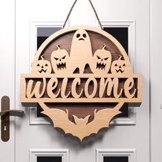 a wooden sign that says welcome with bats and pumpkins hanging from the front door