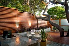 an outdoor patio with wooden fence and trees