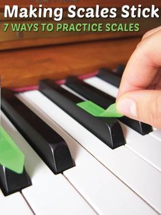 a person is playing the piano with green tape on it's fingers and finger tips