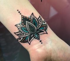 a woman's wrist with a flower tattoo on the left side of her arm