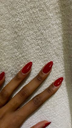 Red acrylic nails Red Oval Nails Short, Red Nails On Black Girls, Short Red Almond Acrylic Nails, Winter Nails For Dark Skin, Medium Length Oval Nails, Muted Red Nails, Cute Nail Designs Almond, Red Nails Ideas Almond, Red Nails Shellac