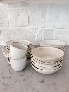 a stack of white dishes sitting on top of a table