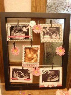 a display case with pictures and flowers on the front, hanging from clothes pegs