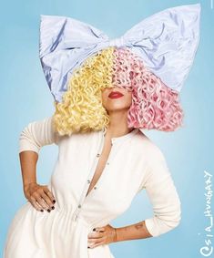 lady in white dress with pink and yellow curly hair wearing a large bow on top of her head