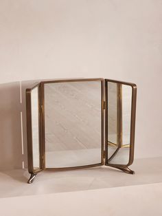 a mirror sitting on top of a table next to a wall