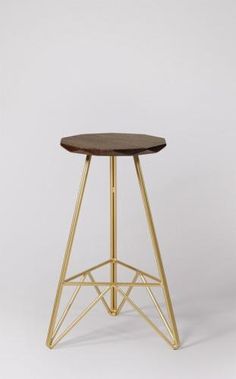 a wooden table with gold metal legs on a white background