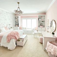 a bedroom decorated in pink and white with a chandelier hanging from the ceiling