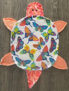 a paper plate shaped like a turtle with colorful butterflies on it's back and wings