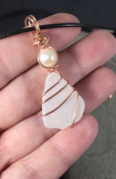 This Beautiful genuine Sea glass necklace is truly unique. Made from white frosted Lake Erie Beach Glass naturally tumbled by the waves, each piece of Beach Glass is its own unique shape, and hand chosen for your necklace.  It is wire-wrapped by hand with pure copper wire and accented with a genuine white freshwater pearl. The beautiful pendant is then hung on a adjustable leather cord necklace that can be worn at 14 inches or as long as 26 inches. I take great care in the creation of each and e White Sea Glass Jewelry Gift, White Glass Necklaces For Beach, White Glass Beach Necklace, White Glass Necklaces For The Beach, White Glass Beach Jewelry, White Sea Glass Necklace As A Gift, White Sea Glass Necklace For Gift, White Recycled Glass Jewelry For The Beach, Handmade White Sea Glass Jewelry