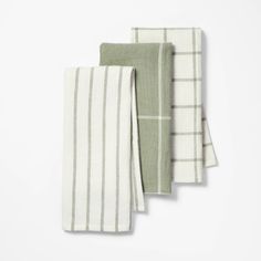 three green and white towels folded on top of each other