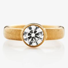 a yellow gold ring with a round diamond