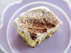 a piece of cake sitting on top of a purple plate with white frosting and sprinkles