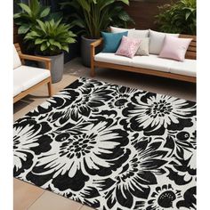 a black and white rug with flowers on it in the middle of a patio area