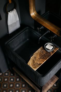 a bathroom sink with a wooden cutting board in it