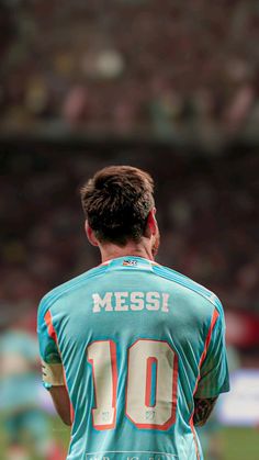 a man standing on top of a soccer field wearing a blue uniform with the number 10 on it