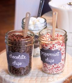 three jars filled with different types of desserts on top of a white cake plate