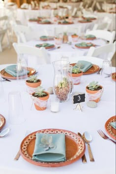 the table is set with plates and place settings for guests to sit down at it