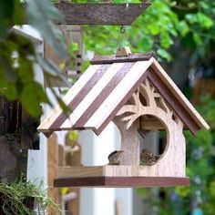 a wooden bird house hanging from a tree