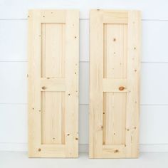 two unfinished wooden doors against a white wall