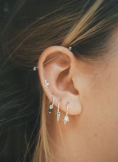 a close up of a person with ear piercings on their ears and behind the ear