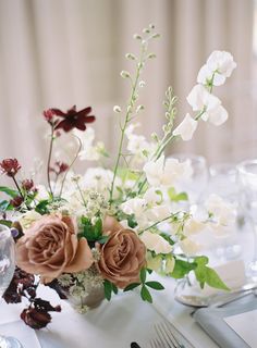 the table is set with flowers and silverware