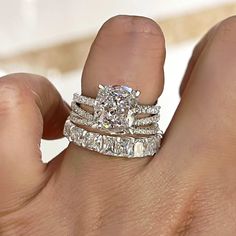 a woman's hand with two wedding rings on top of her finger and the ring has three rows of diamonds in each band