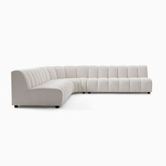 a white sectional couch sitting on top of a white floor