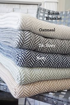 four folded towels stacked on top of each other in front of a fireplace with the words, susan blanket oatmeal