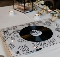 a record player sitting on top of a table next to candles and some white flowers