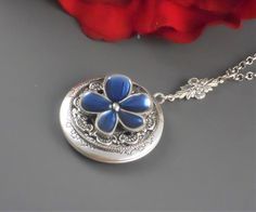 Very royal feminine antique silver locket is decorated with Victorian style antique silver floral frame. I have set pewter blue posey flower in the middle of locket. Pendant is hanging from a antique silver floral rosary link. Necklace is finished with antique silver chain and antique silver clasp. Locket is 32 mm in size. It opens and has room for two photos inside. Please note: I DO NOT DO ENGRAVING OR INSERT PICTURES! Thanks for looking:) Mani Vintage Charm Flower Pendant Jewelry For Wedding, Antique Flower Necklaces For Weddings, Antique Silver Round Pendant Necklace For Wedding, Antique Blue Jewelry For Wedding, Silver Round Locket Necklace For Wedding, Elegant Antique Silver Locket Necklace For Anniversary, Silver Medallion Locket Necklace For Wedding, Silver Vintage Charm Necklaces For Weddings, Silver Pendant Locket Necklace For Wedding