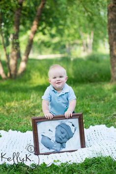 a baby is sitting on a blanket with a picture frame in front of him that has an image of a baby's head