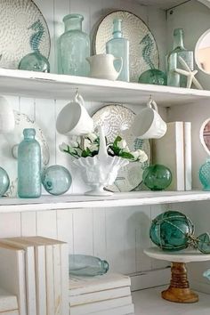 the shelves are filled with glass vases and dishes