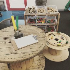 a wooden table with some sort of crafting supplies on it in a room filled with toys and other items