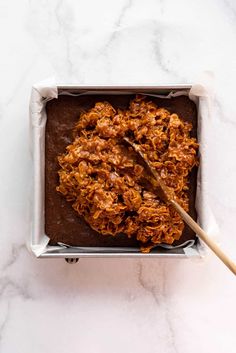 a pan filled with food sitting on top of a counter next to a spatula