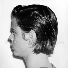 an old black and white photo of a man's profile with short hair in the back