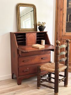 an old wooden desk with a mirror and chair