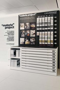 an advertisement for the material project is displayed on a wall in a room with black and white walls