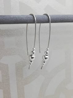 Sterling silver long dangle earrings with solid sterling silver beads, these modern earrings make a real statement. The earrings are made with one continuous piece of silver wire which is hand forged and polished to a high shine.  They are light weight and very comfortable to wear. The drop measures 4.5cm.  Silver width 0.9mm(US 19 Gauge) If you would like these made longer or shorter please convo me. All earrings are handmade in the UK using traditional Silversmithing techniques. Shop all Karma Cheap Silver Beaded Earrings, Cheap Silver Earrings With Large Beads, Affordable Trendy Silver Beaded Earrings, Drop Earrings Silver Handmade Jewelry, Cheap Silver Beaded Pierced Earrings, Cheap Sterling Silver Beaded Earrings, Cheap Handmade Sterling Silver Earrings, Affordable Sterling Silver Drop Earrings, Cheap Adjustable Silver Beaded Earrings