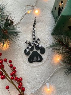 a dog paw ornament on a white towel next to christmas decorations and lights