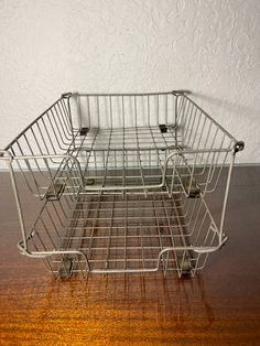 a wire basket sitting on top of a wooden table