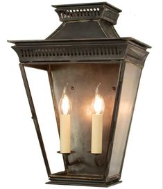 an old fashioned lantern with two candles on the front and one light on the back