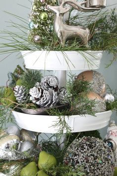 three tiered christmas tree with pine cones, ornaments and silver deer figurines