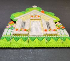 a close up of a knitted house ornament