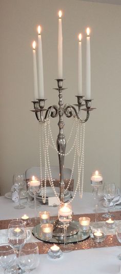 a table topped with lots of white candles