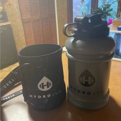 two coffee mugs sitting on top of a wooden table next to eachother