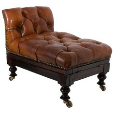 a brown leather chaise lounge chair on casteors with studded feet and wheels