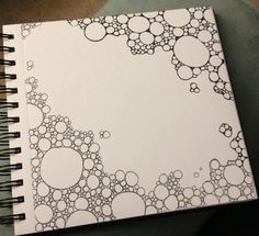 an open spiral notebook with black and white circles